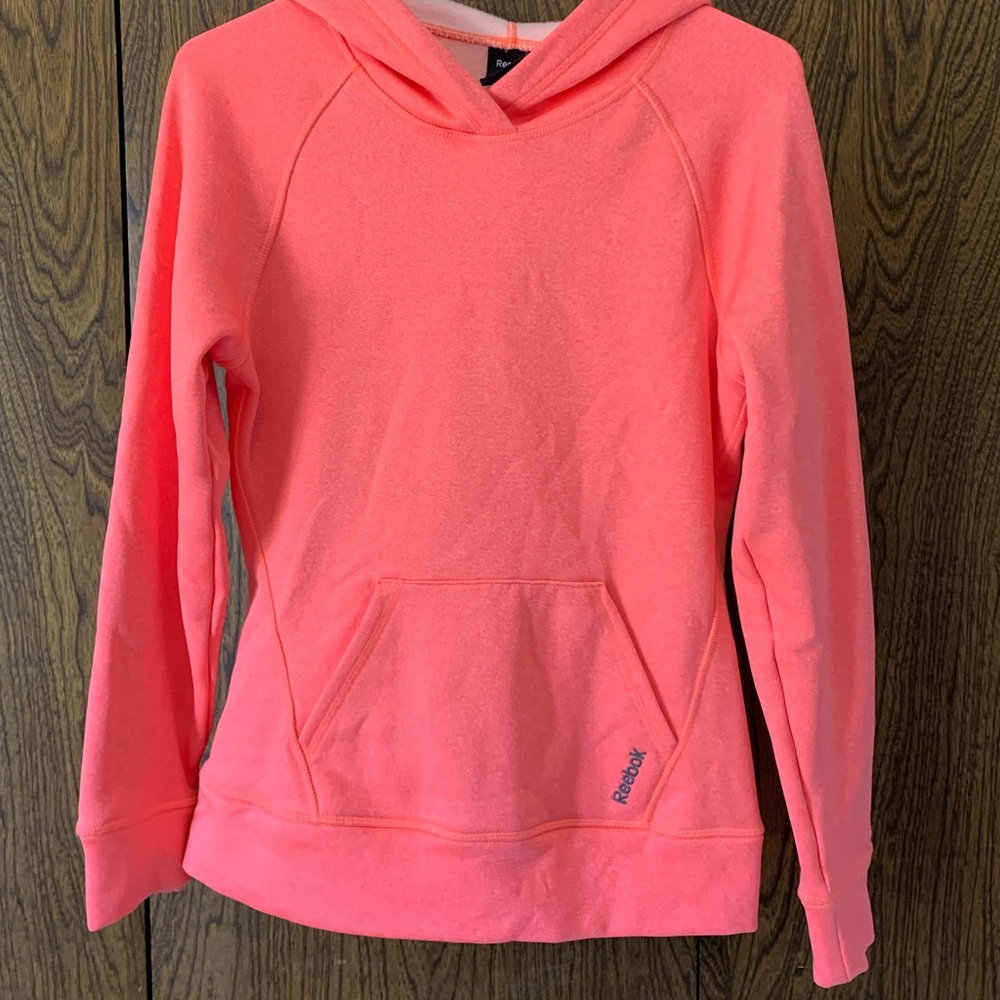 This is an orange Reebok sweatshirt/hoodie. It is in great condition.